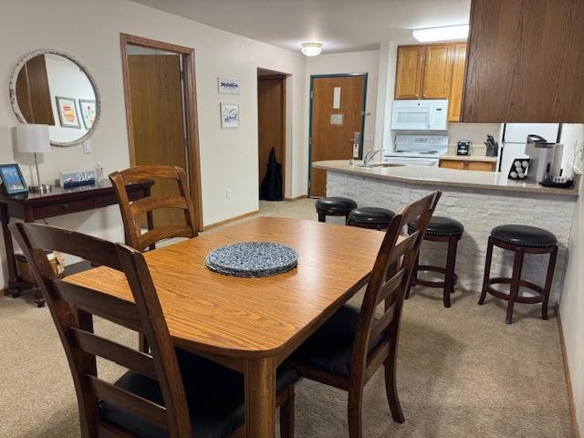 dining area featuring light colored carpet