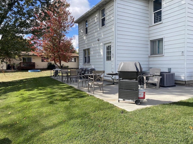 back of house with central AC unit, a patio, and a yard