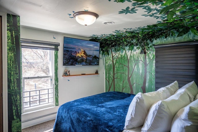 bedroom with a baseboard heating unit, multiple windows, and visible vents