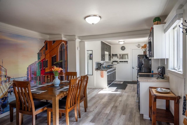 dining room featuring light wood-style flooring and baseboards