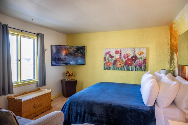 bedroom featuring baseboards and wood finished floors