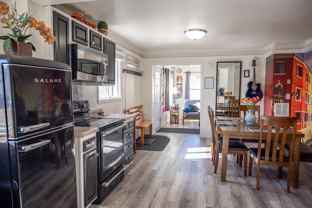 kitchen with light wood-style floors, black appliances, and light countertops