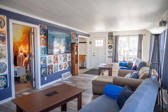 living area featuring wood finished floors, visible vents, and baseboards