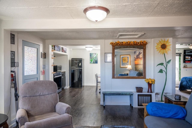 living area featuring dark wood-style floors, baseboards, and a textured ceiling