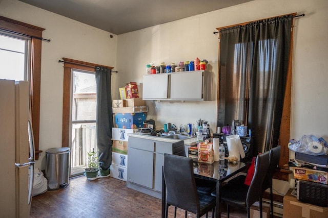 kitchen featuring light countertops, white cabinets, wood finished floors, and freestanding refrigerator