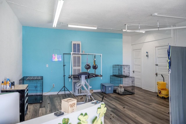 interior space with a textured ceiling and wood finished floors