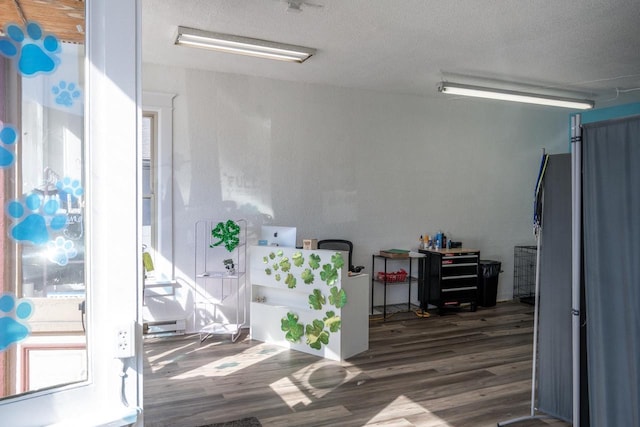 interior space with a textured ceiling and wood finished floors