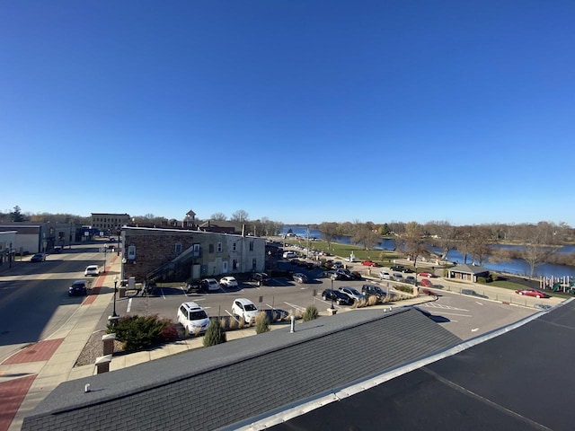 view of street with a water view, sidewalks, and curbs