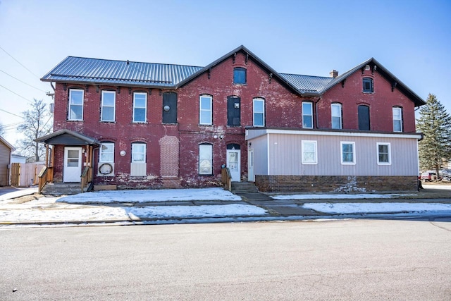 view of front of property with metal roof and brick siding