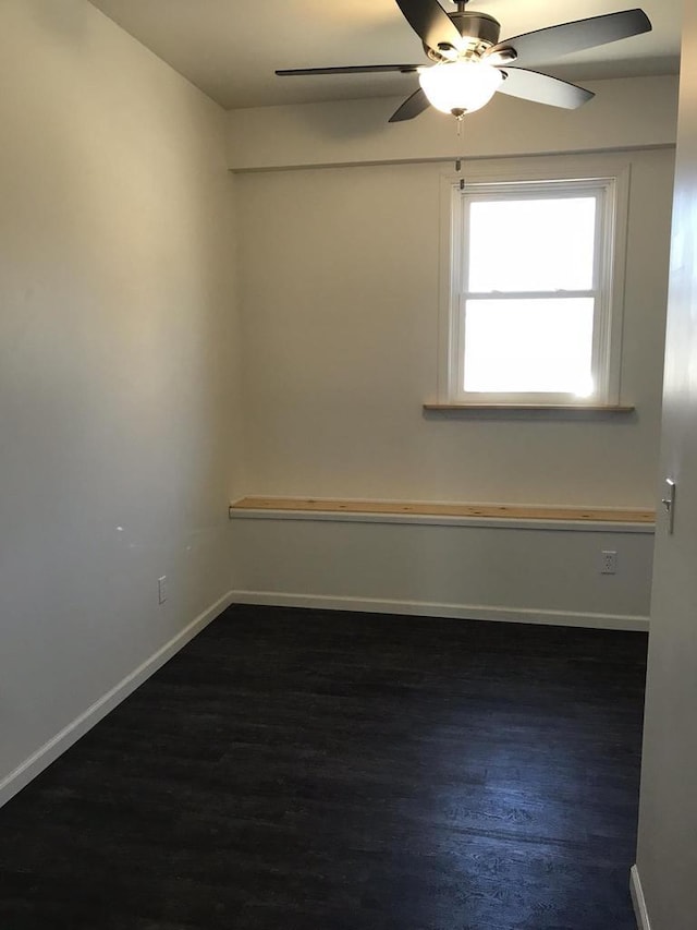 empty room with dark wood-style floors, ceiling fan, and baseboards