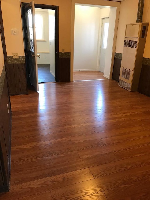 unfurnished living room with baseboards and wood finished floors