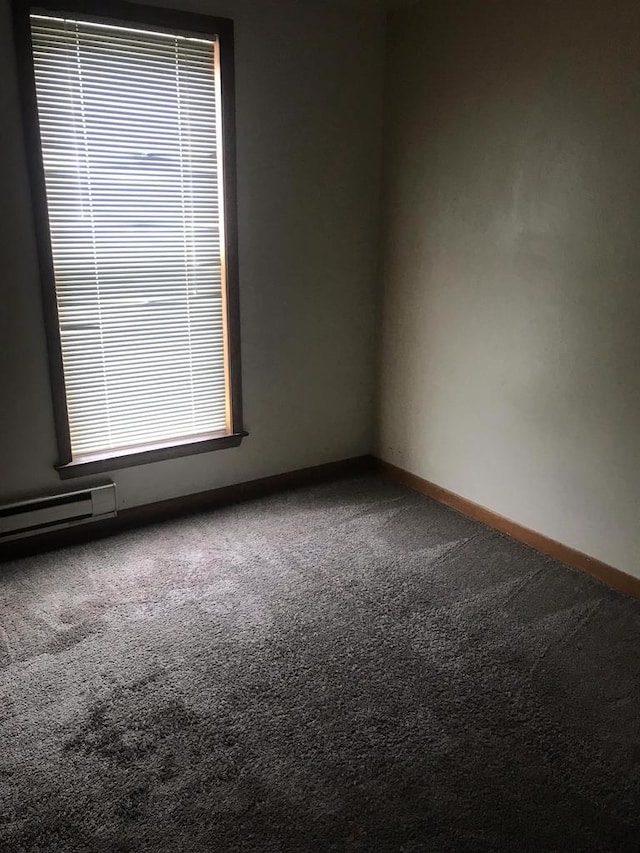 carpeted empty room featuring baseboards and baseboard heating
