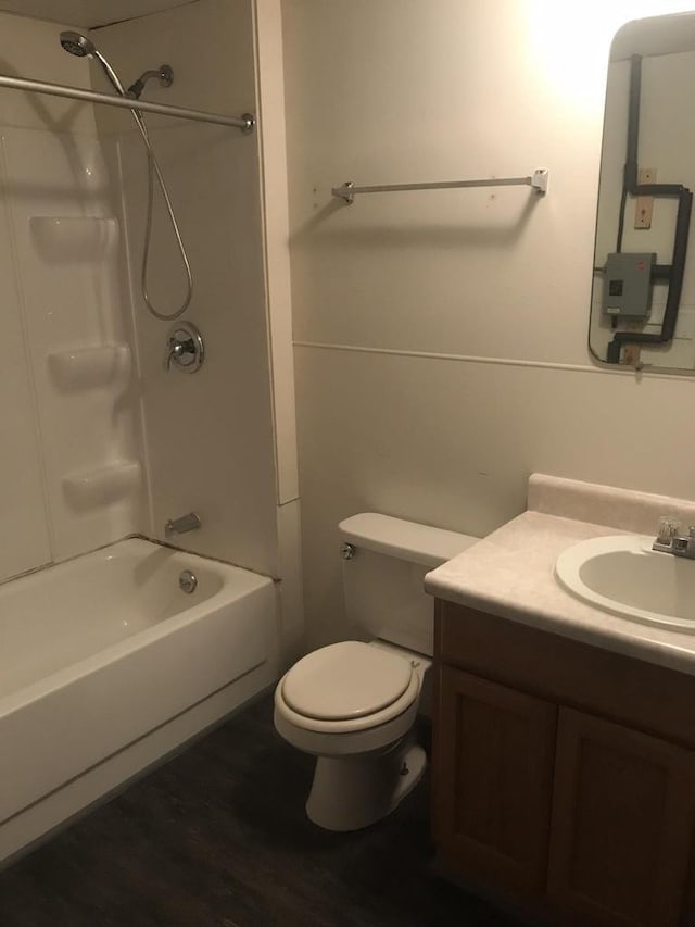 bathroom featuring vanity, bathing tub / shower combination, toilet, and wood finished floors