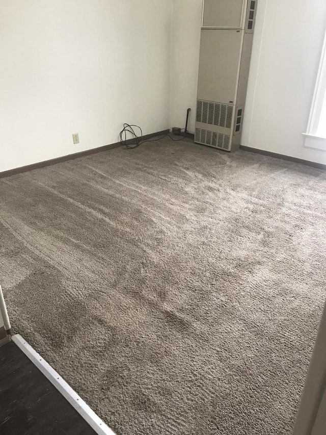 carpeted empty room featuring baseboards