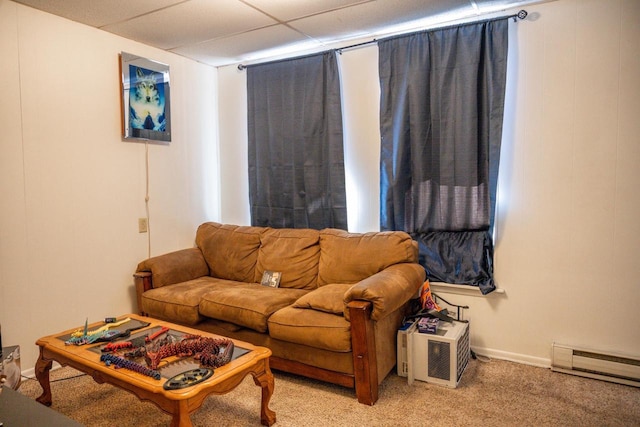 living room with a paneled ceiling, a baseboard radiator, baseboards, and light colored carpet