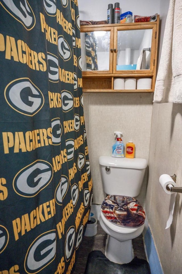 full bathroom with toilet and a shower with curtain