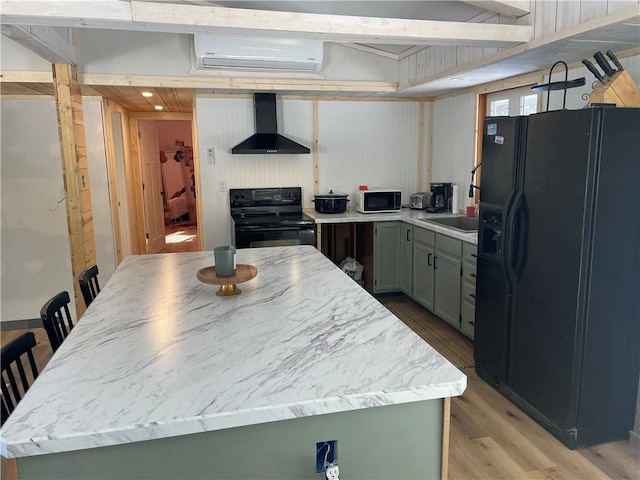 155 Zach St, Glidden, WI 54527 - kitchen with light wood finished floors, wall chimney exhaust hood, an AC wall unit, black appliances, and a sink