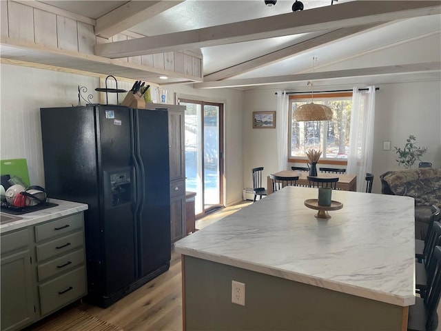 155 Zach St, Glidden, WI 54527 - kitchen featuring lofted ceiling with beams, black refrigerator with ice dispenser, light wood finished floors, and a healthy amount of sunlight