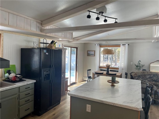 155 Zach St, Glidden, WI 54527 - kitchen featuring lofted ceiling with beams, black refrigerator with ice dispenser, light wood-type flooring, and a kitchen island