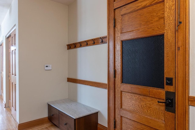 mudroom featuring light wood-style flooring and baseboards