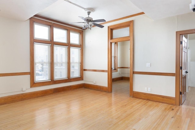 unfurnished room featuring a ceiling fan, baseboards, and wood finished floors