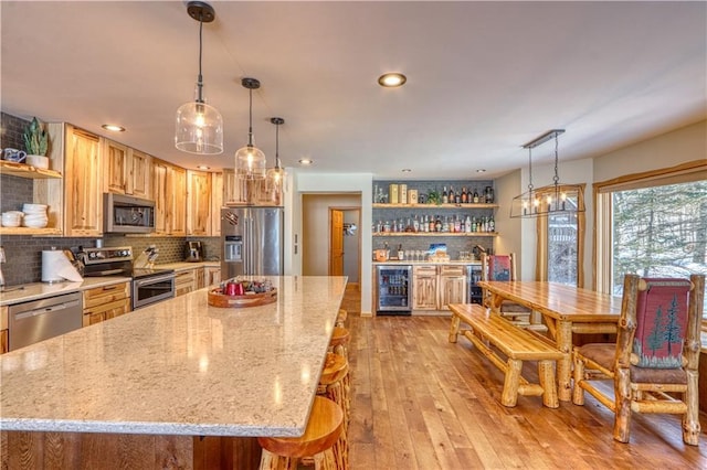 kitchen featuring light wood-style flooring, wine cooler, appliances with stainless steel finishes, and open shelves