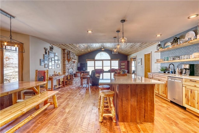 kitchen featuring a center island, open shelves, lofted ceiling, light wood-style flooring, and stainless steel dishwasher