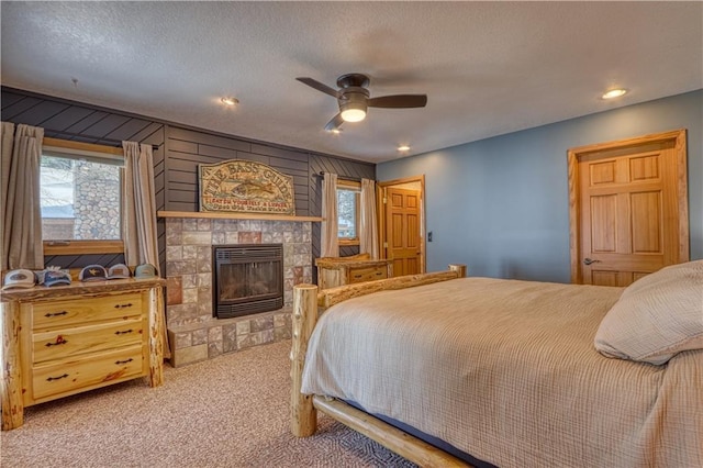 bedroom with carpet floors, recessed lighting, a glass covered fireplace, ceiling fan, and a textured ceiling