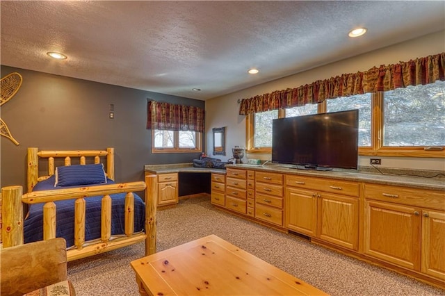 kitchen with a textured ceiling, recessed lighting, and light colored carpet