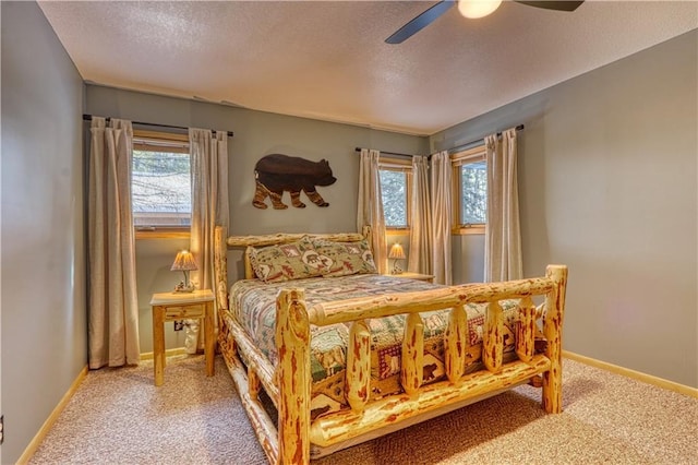 carpeted bedroom featuring a textured ceiling, ceiling fan, and baseboards