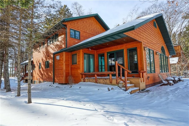 snow covered property with a porch