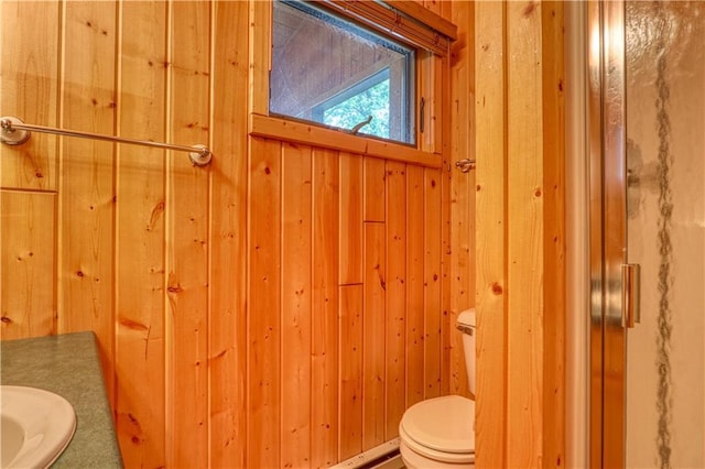 bathroom with toilet and wooden walls