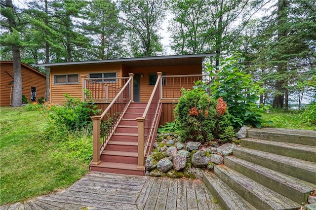 view of front of house featuring stairs and a wooden deck