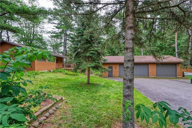 view of front of house featuring a garage, log veneer siding, and a front yard