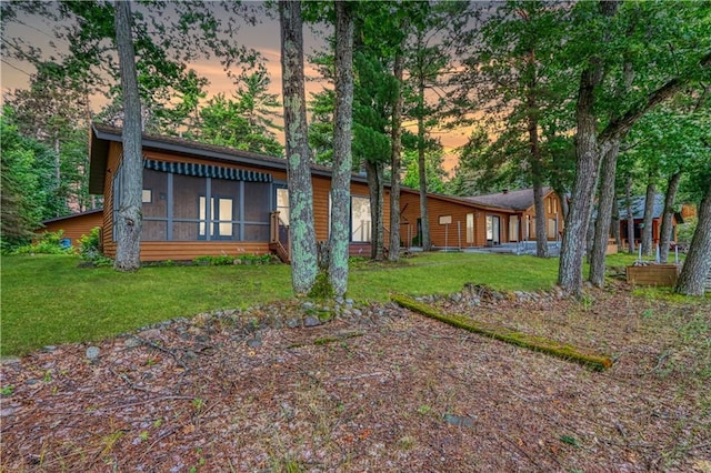 exterior space featuring a sunroom and a lawn