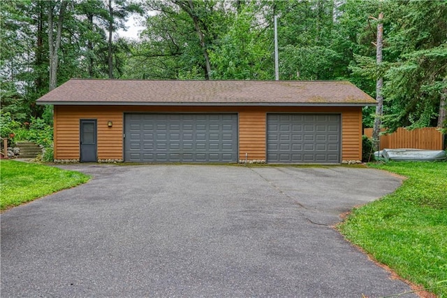 detached garage featuring fence