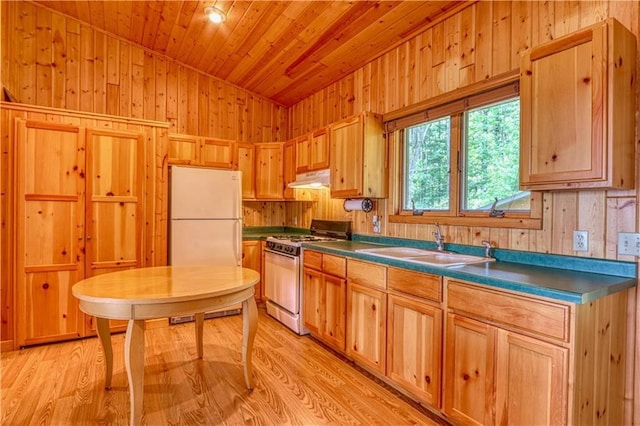 kitchen featuring under cabinet range hood, a sink, wood ceiling, freestanding refrigerator, and gas range oven