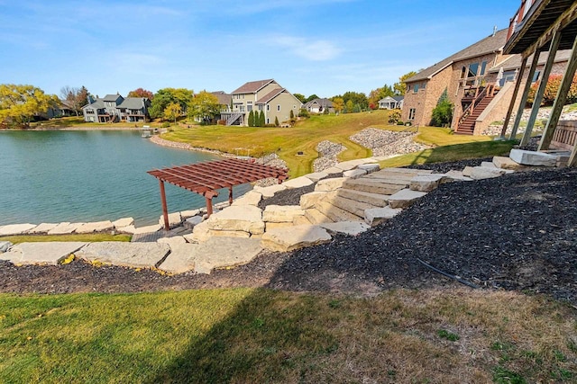 view of yard with a residential view, a water view, and stairway