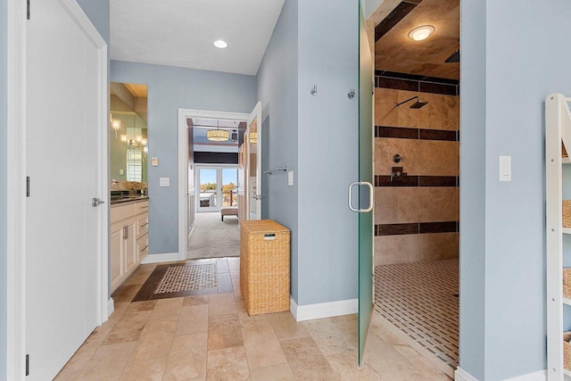 bathroom with a shower stall, baseboards, and vanity