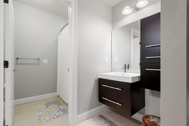 bathroom featuring tile patterned flooring, vanity, and baseboards