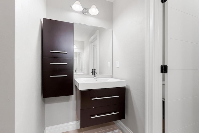 bathroom with vanity, baseboards, and tile patterned floors