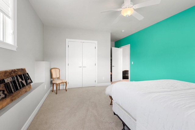 carpeted bedroom featuring a ceiling fan, a closet, and baseboards