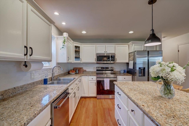 kitchen featuring a sink, appliances with stainless steel finishes, light wood-style flooring, and white cabinets