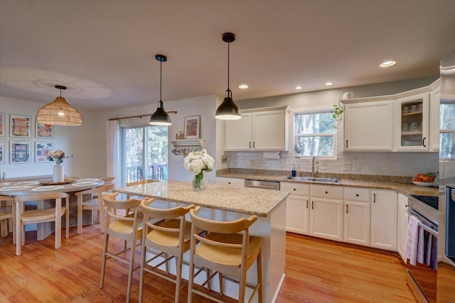 kitchen with light wood-style flooring, white cabinets, and a sink