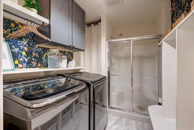 clothes washing area featuring washer and dryer, visible vents, cabinet space, and marble finish floor