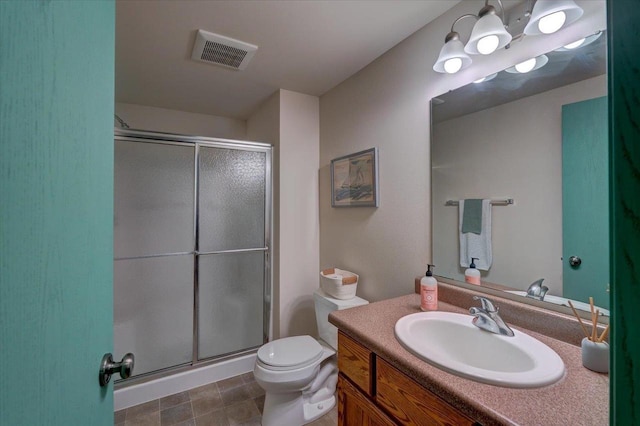 bathroom with visible vents, toilet, a stall shower, and vanity