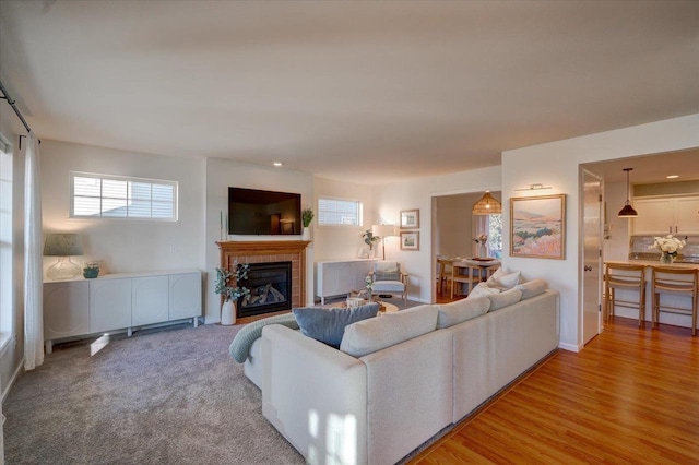 living room featuring light wood-style flooring and a tile fireplace