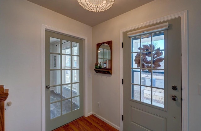 doorway to outside featuring wood finished floors and baseboards