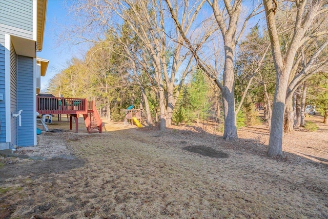 view of yard with a wooden deck and playground community