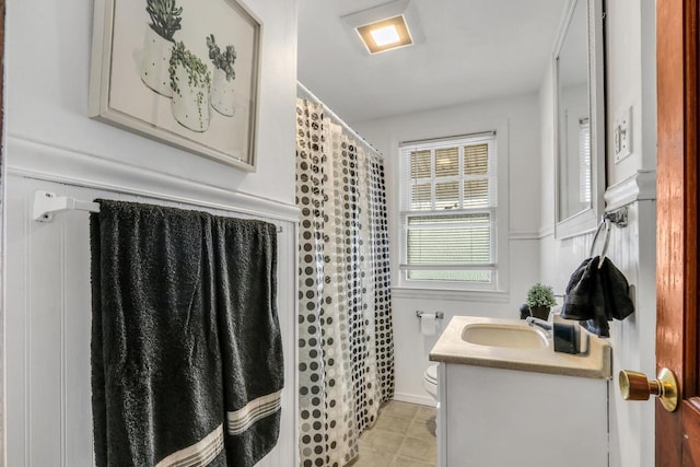 full bathroom featuring a shower with shower curtain, vanity, and toilet